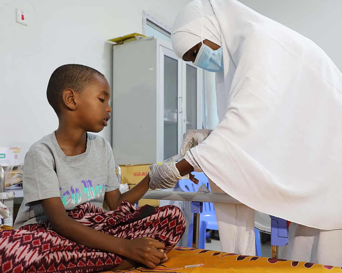 A nurse administers medicine to a child