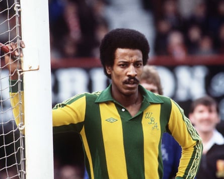 Brendon Batson standing next to a goalpost wearing a yellow and green striped football shirt.
