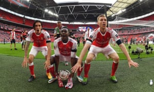 Hector Bellerin, Danny Welbeck and Per Mertesacker celebrate in front of the Arsenal fans.