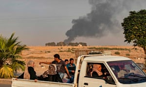 Civilians ride a pickup truck as smoke billows following Turkish bombardment in the north-eastern town of Ras al-Ayn along Syria’s border with Turkey on Wednesday. 5062.jpg?width=300&quality=85&auto=forma