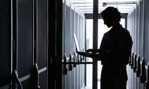 person on laptop in library stacks