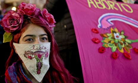 A woman wearing a handkerchief embroidered with a uterus and the Spanish word for “free” participates in a pro-abortion march in Santiago, Chile