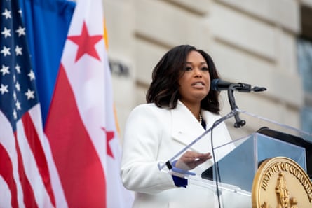 person wearing white stands behind podium and speaks into microphone