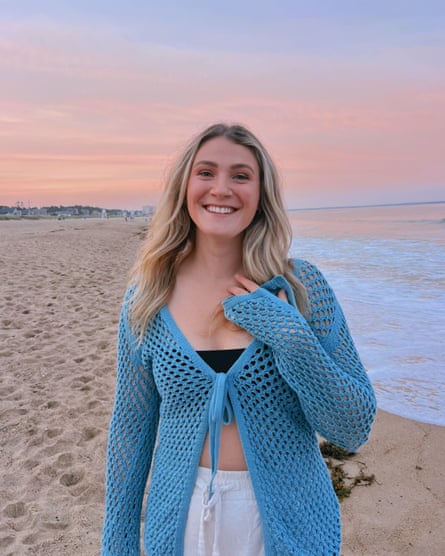 A young woman smiles and poses at the beach