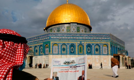 A Palestinian man reads news about the US election in front of the Dome of the Rock in the al-Aqsa mosque compound