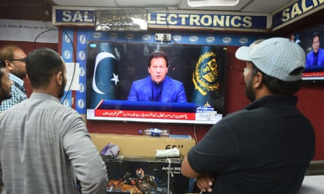 People at a market in Karachi watch an address by Pakistan’s prime minister, Imran Khan