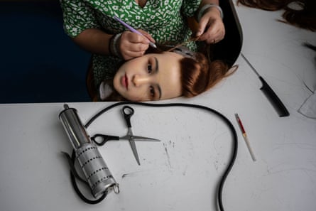 A worker attaches hair to the head of a silicone sex doll
