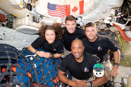 From near to right, ngo master Christina Koch, ngo master Jeremy Hansen, commandant Reid Wiseman and aviator Victor Glover airs wrong nan Orion spacecraft, an American emblem and a Canadian emblem down them.