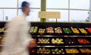 FILE PHOTO: A man walks past packaged fruit and vegetables during the opening ceremony for Tesco's Fresh & Easy Neighborhood supermarket in Los Angeles November 7, 2007.  REUTERS/Lucy Nicholson (UNITED STATES)/File Photo
