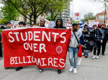 people hold a banner that reads ‘students over billionaires’