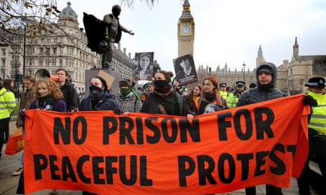 Supporters of Just Stop Oil march across Parliament Square in December 2023  to protest the growing number of activists that are being held on remand in prison following being arrested during peaceful protest.