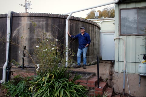 Stuart Riles stands near his water tank