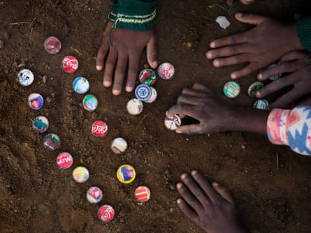 Children playing with bottle tops in the dust in Chowa township in Kabwe