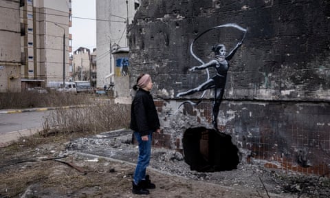 Yana Psariova looks at a mural by the street artist Banksy, a short walk from her destroyed apartment in Irpin, Kyiv oblast.