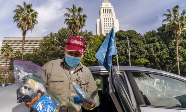 Jose Luis Guevara, a member of the Mobile Workers Alliance, shows personal protective equipment he provides freely to ride-sharing customers for their safety, outside Los Angeles City Hall.