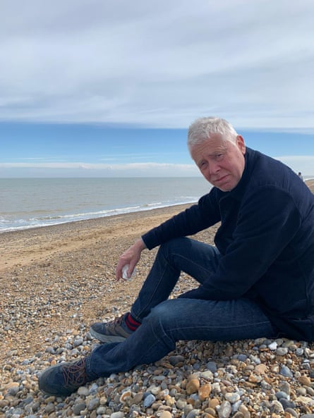 Jonathan Dyson, sitting on a pebble beach