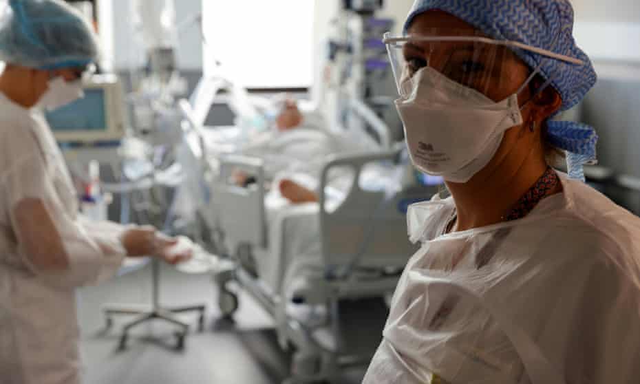 Nurses wearing protective masks and suits work in the intensive care unit at Victor Provo hospital in Roubaix, France.