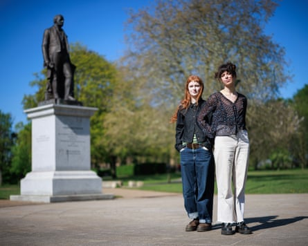 Two women standing in front of a statue in Peel Park that depicts Joseph Brotherton, the first ever MP for Salford.