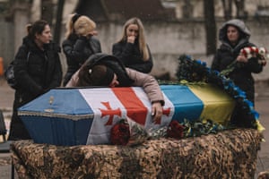 Relatives, friends and comrades mourn next to the coffins of servicemen Nodar Nasirov and Giorgi Gogiashvili from the Georgian national legion during a funeral ceremony for fallen soldiers in Kyiv, Ukraine