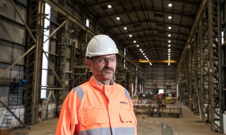 man in hard hat and overalls in big industrial building