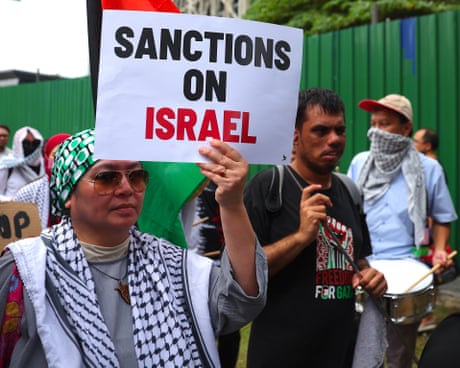Protesters holding placards saying 'Sanctions on Israel'.