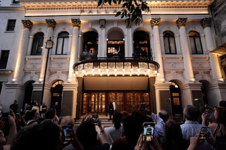 Rachel Zegler is on the balcony of the London Palladium, singing while crowds watch from the pavement below