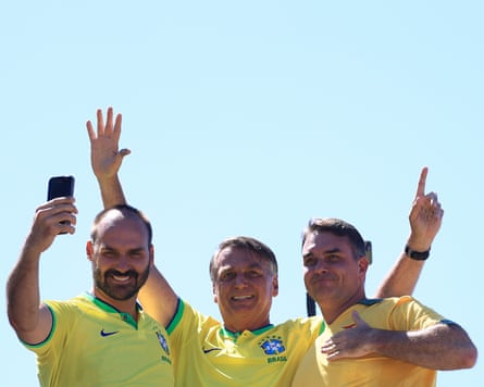 Jair Bolsonaro, with his sons Eduardo (L) and Flavio (R), waves his supporters during a rally at Copacabana beach in April 2024.