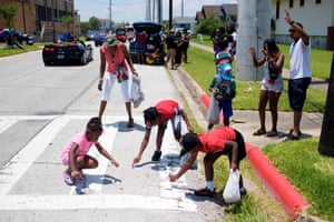 Children pick up candy thrown from a parade float during a Juneteenth parade in Galveston, Texas