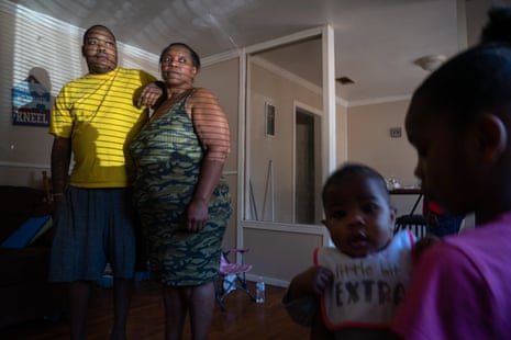 A man and woman pose for a portrait with a young girl and a baby in the foreground