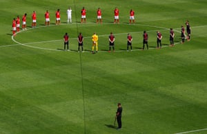 Players observe a minutes silence for the victims of the coronavirus before the match.