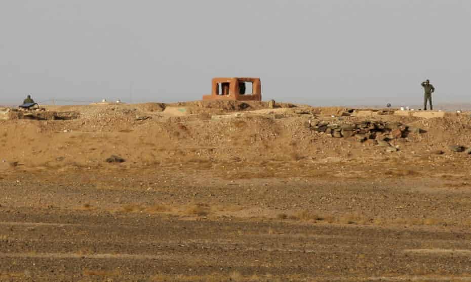 Soldiers from the Moroccan army stand behind a fortified earthwork on the Berm.