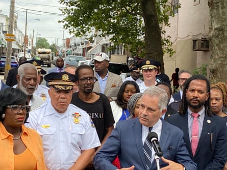 A man speaks into a mic in front of a crowd