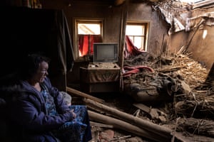Leda Buzinna sits inside her home that was seriously damaged by shelling when two S-300 missiles hit a rural neighbourhood in Krasnotorka