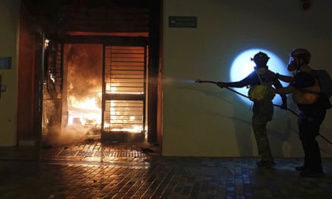First aid volunteers work to extinguish a fire set by local residents at a building of the Fai Ming Estate, in the Fanling district of Hong Kong, after the Hong Kong government announced it would requisition the unoccupied housing project to house quarantined patients of the new viral coronavirus illness.
