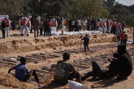 People next to lines of graves