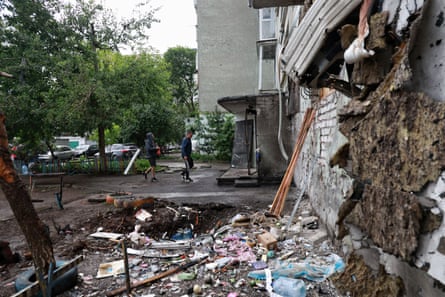People’s belongings lie scattered in a crater by an apartment block.