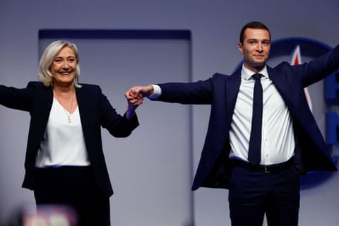 Bardella holds the hand of Marine Le Pen after the results during the National Rally party’s Congress in Paris in November 2022.