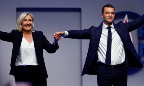 Jordan Bardella, newly-elected president of the RN party, holds the hand of Marine Le Pen after the results during the National Rally party's Congress in Paris, France.