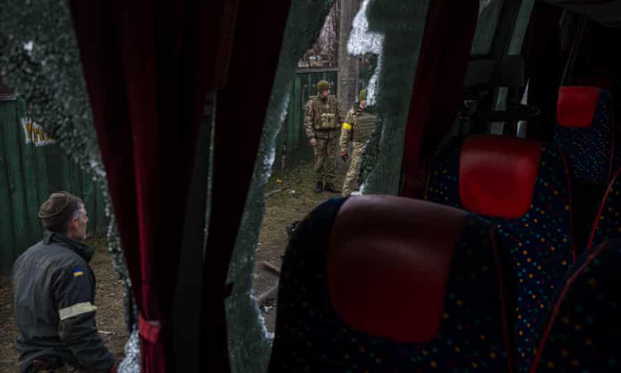 Ukrainian soldiers stand outside a machine-gunned bus, after an ambush in the city of Kyiv, Ukraine, Friday, March 4, 2022. (AP Photo/Emilio Morenatti)