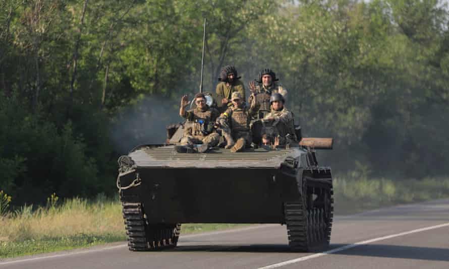 Russia-Ukraine war latest: fierce fighting in Sievierodonetsk; UK ‘deeply concerned’ by death sentences for Britons in Donetsk – live | World news 8 Ukrainian soldiers on a road near the small city of Bakhmut.