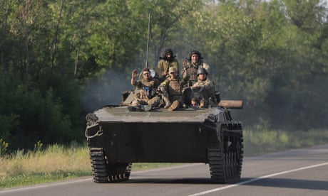 Ukrainian soldiers ride an armoured personnel carrier near Bakhmut