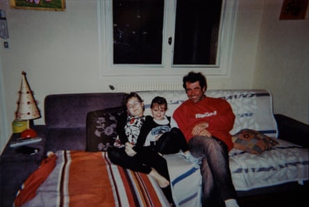 A man and two young girls sitting on a sofa smiling
