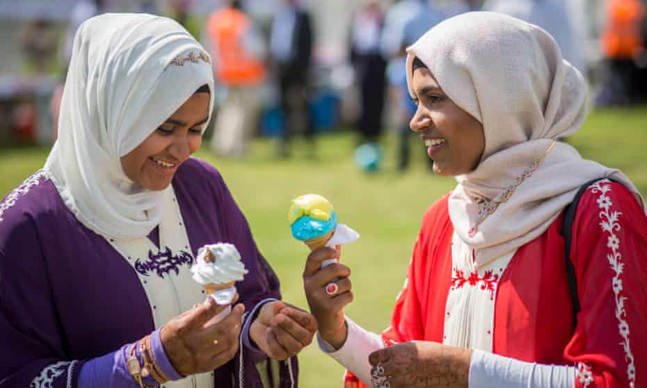 Women eat ice cream at Southwark Eid festival in Burgess Park, south London.