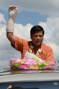 Naing Ngan Linn waves with his bandaged arm to supporters during a campaign in Tharketa township in Yangon.
