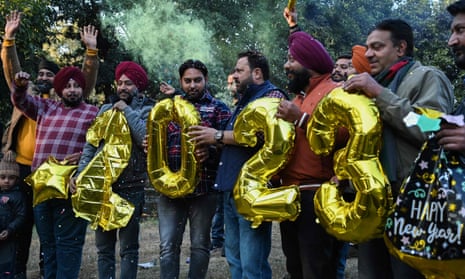 Las personas sostienen globos con forma numérica durante las celebraciones de la víspera del Año Nuevo en Amritsar el 31 de diciembre de 2022.