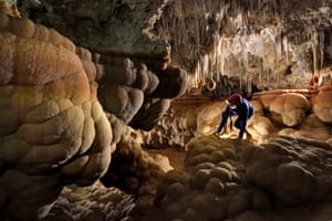 An explorer climbs over giant cave mammillaries that were once underwater in Carlsbad Caverns, New Mexico.