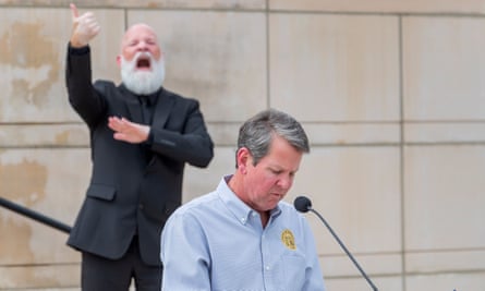 Governor Brian Kemp addresses the media at the state capitol building, accompanied by a sign language interpreter.