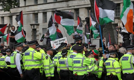 Police officers form a cordon in Whitehall as protesters waving Palestinian flags gather, July 2024