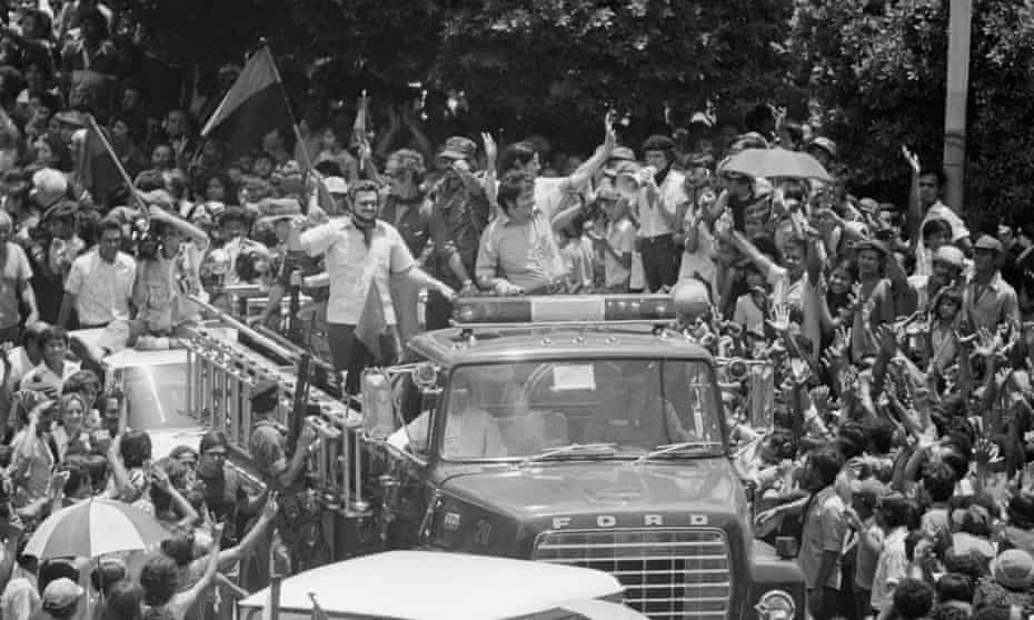 Members of the five-man junta of the Sandinista provisional government wave from the top of a fire truck as they enter the main square in downtown Managua, 1979.