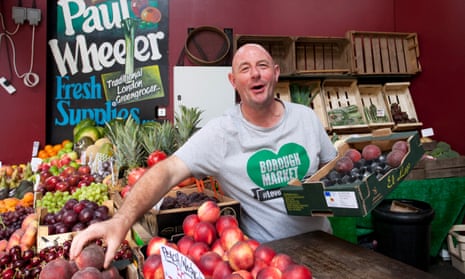Paul Wheeler at his veg stall, placing a peach from a box